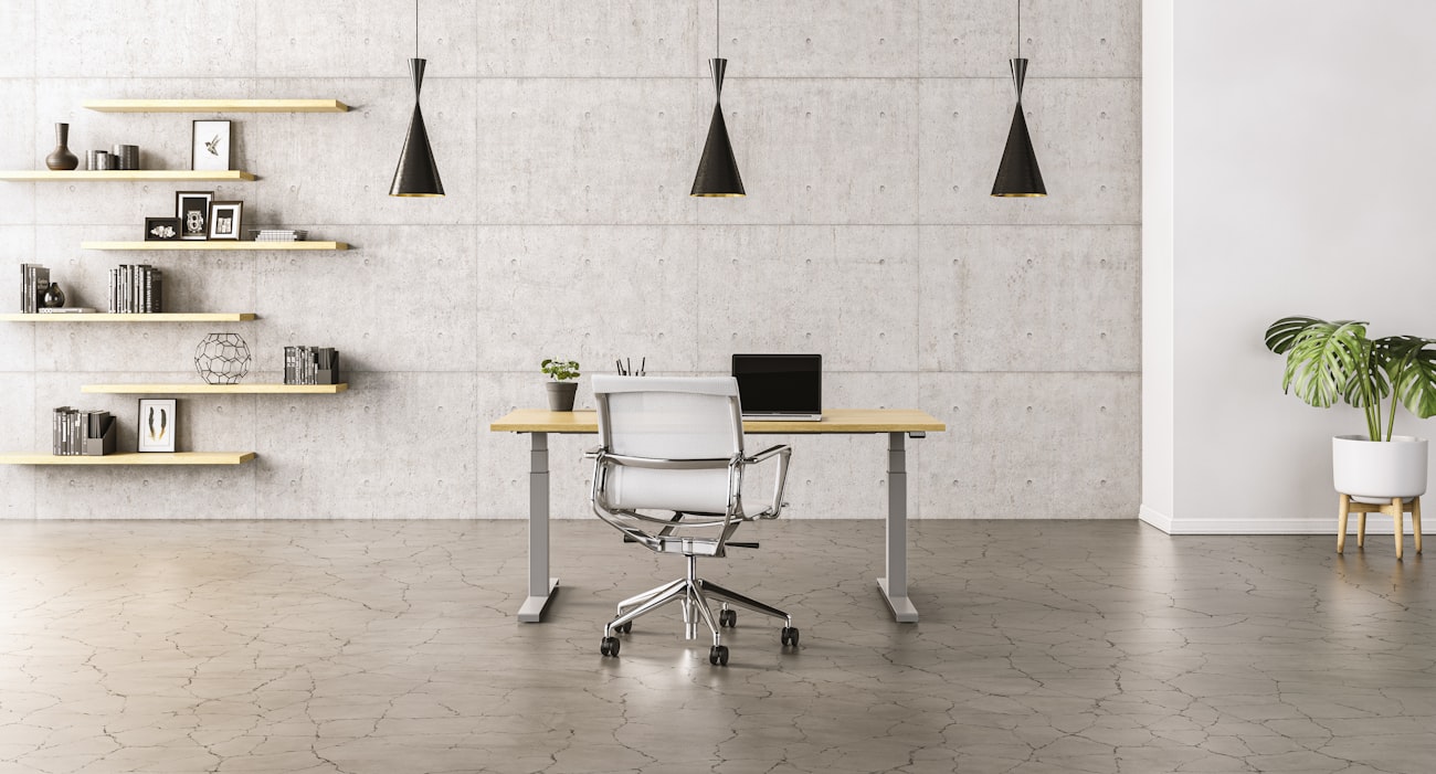 Postazione di lavoro essenziale con portatile, sedia e mensole su parete chiara
